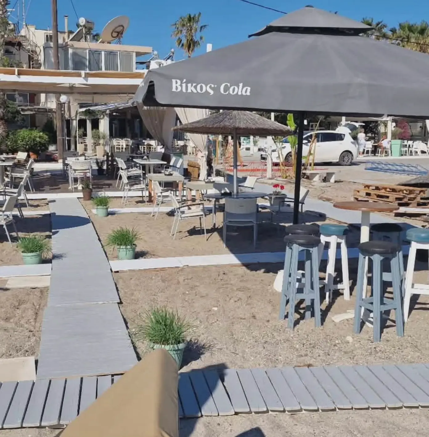 Beach bar stools and umbrellas in the sand