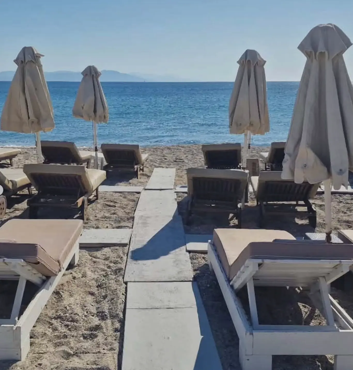 Sunbeds and parasols right at the water's edge