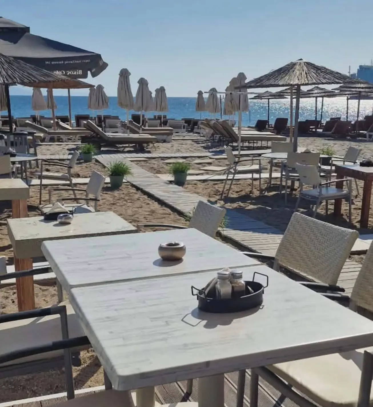 Table set on the boardwalk looking out over the sunbeds