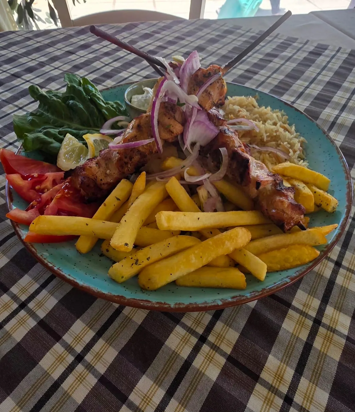 Chicken souvlaki skewers with fries and rice