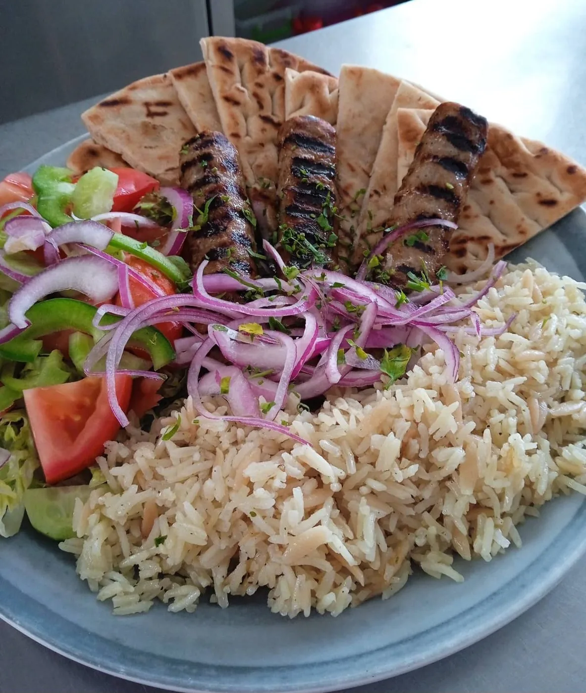 Bifteki with warm pita, pilaf and village salad